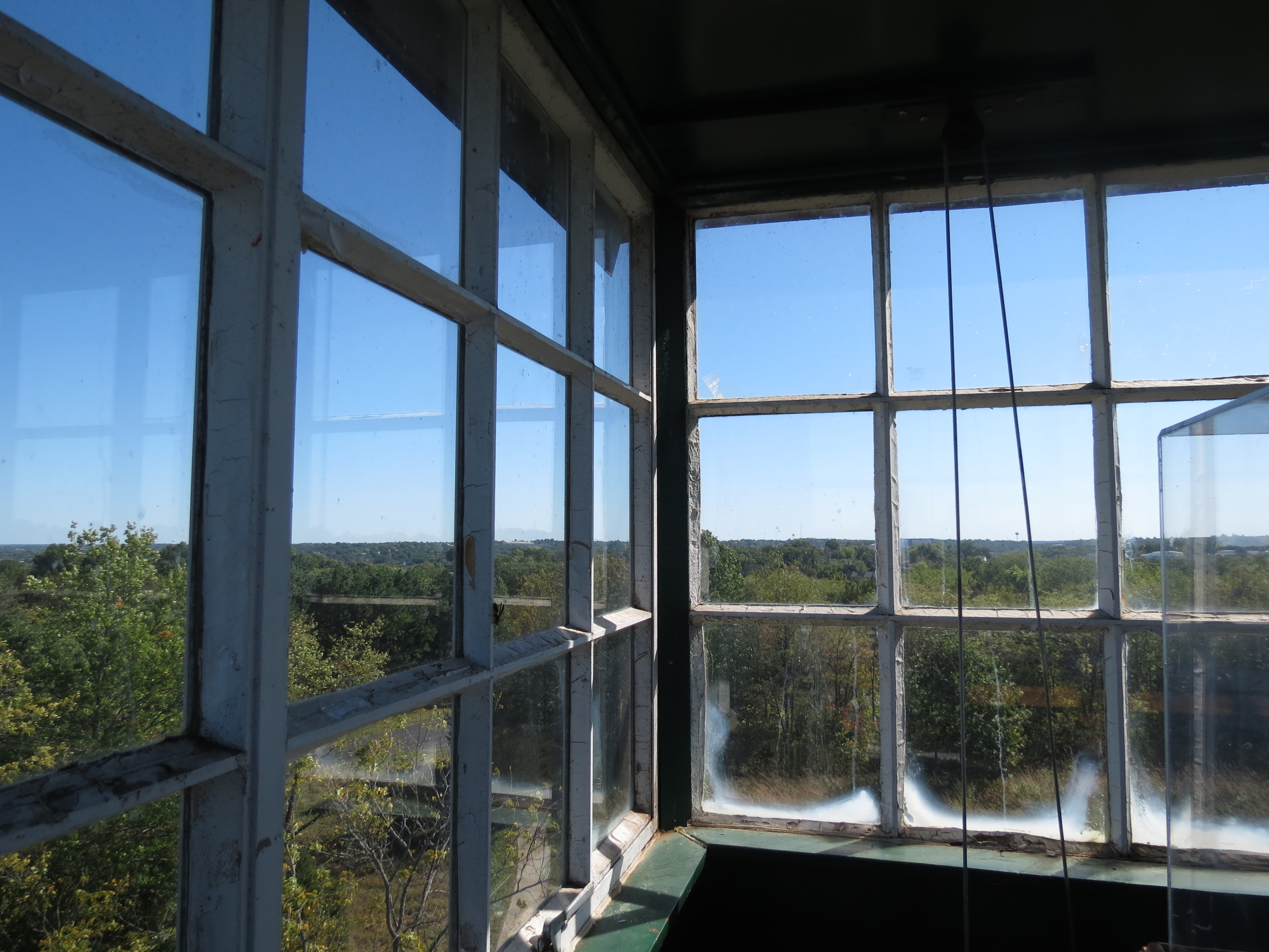 The view of nearby trees and scenery through frosted windows at the top of the tower.